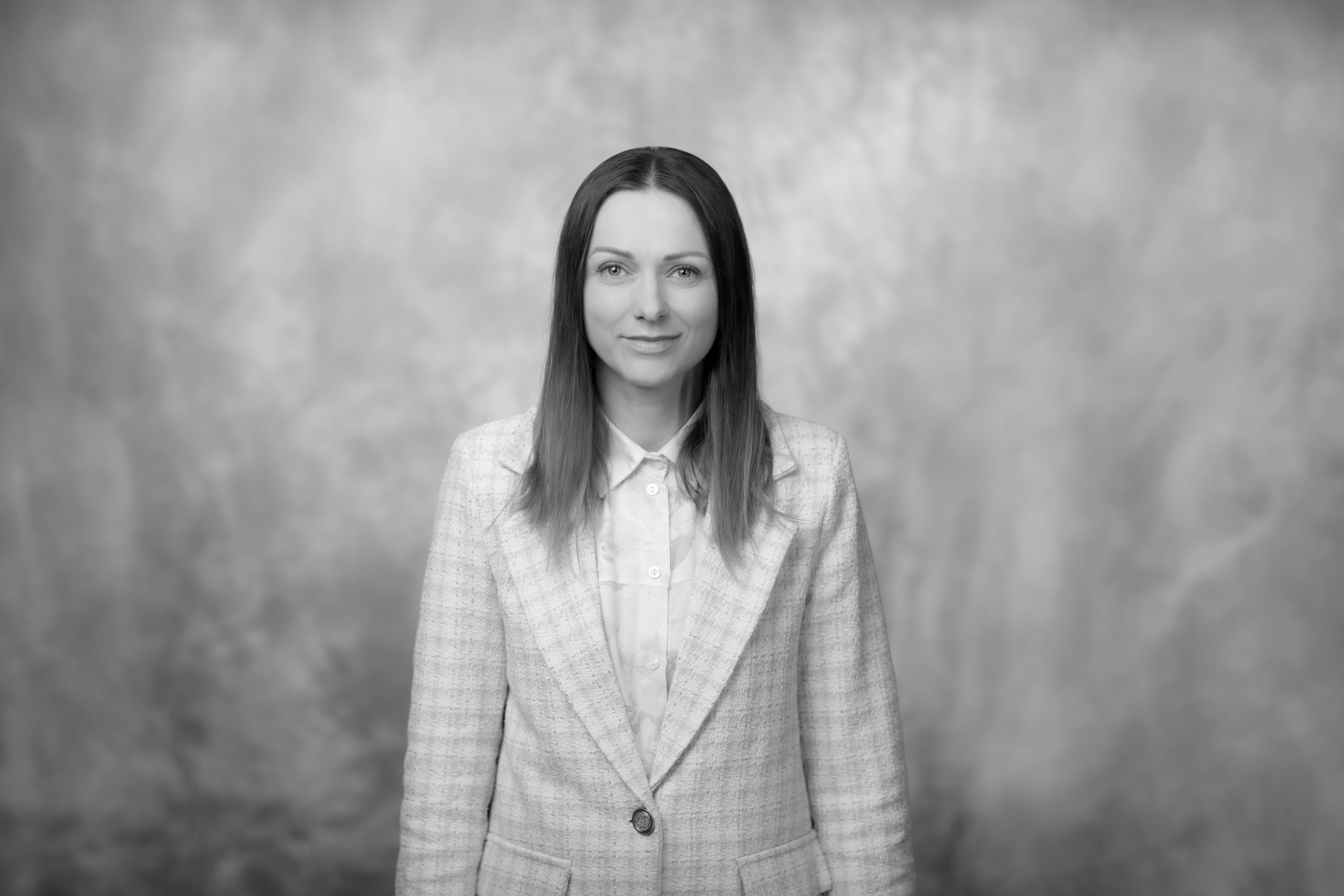 porter młodej uśmiechniętej kobiety z rozpuszczonymi włosami w formalnym jasnym stroju