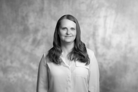 czarno biały portret uśmiechniętej kobiety w długich włosach, w jasnej bluzce