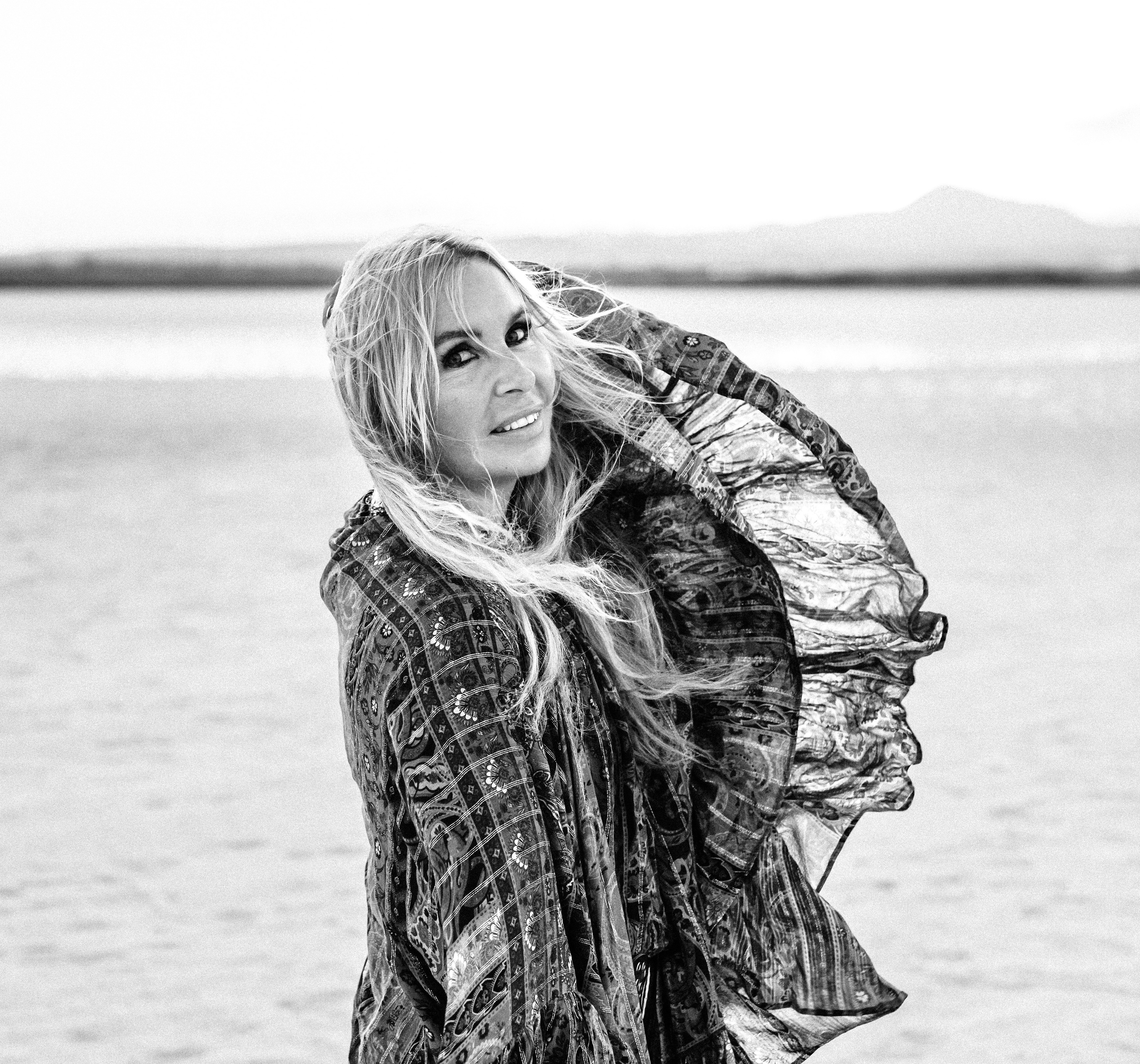 artystyczna fotografia kobiety pozującej podczas wiatru poruszającego jej blond włosy i szal